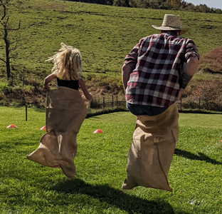 Children hopping inside burlap sacks during a sack race using traditional burlap sack race bags